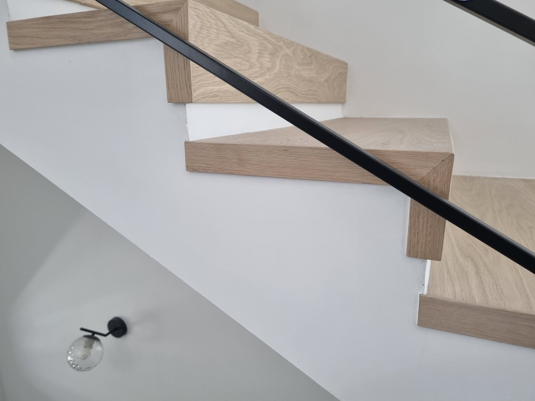Dettaglio dei gradini in legno e del parapetto nero