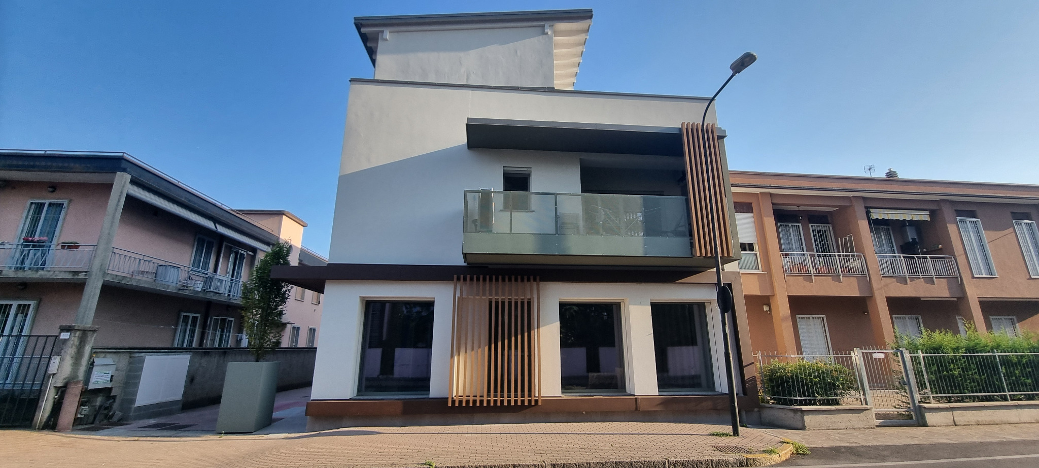 Fronte principale con balcone, aggetti e schermature verticali