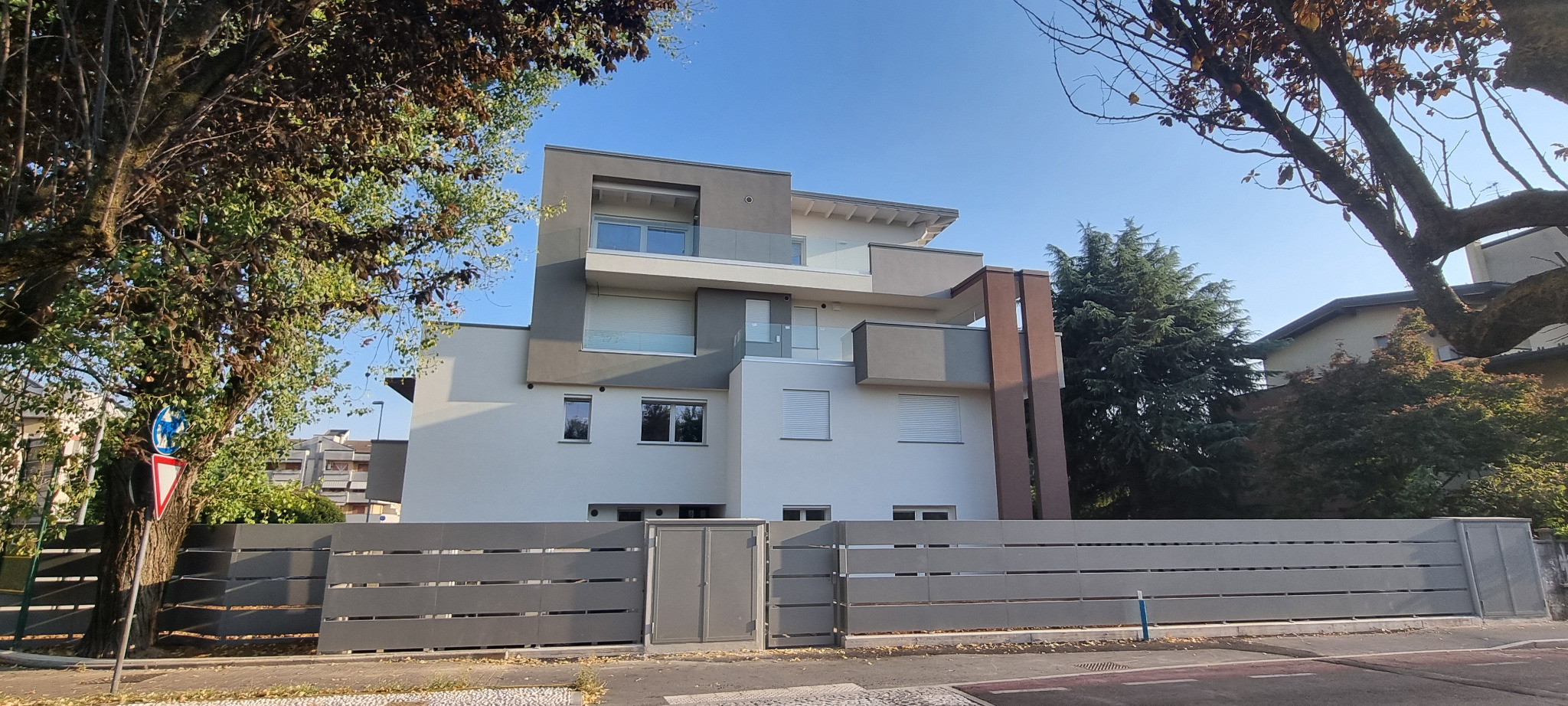 Prospetto laterale del complesso residenziale incorniciato dagli alberi