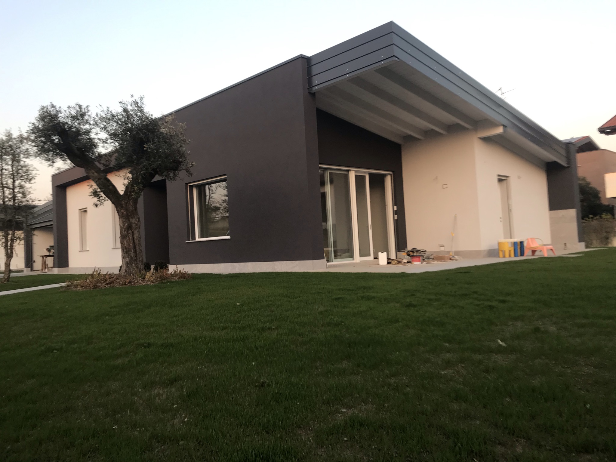 Casa contemporanea a un piano con portico affacciato sul giardino