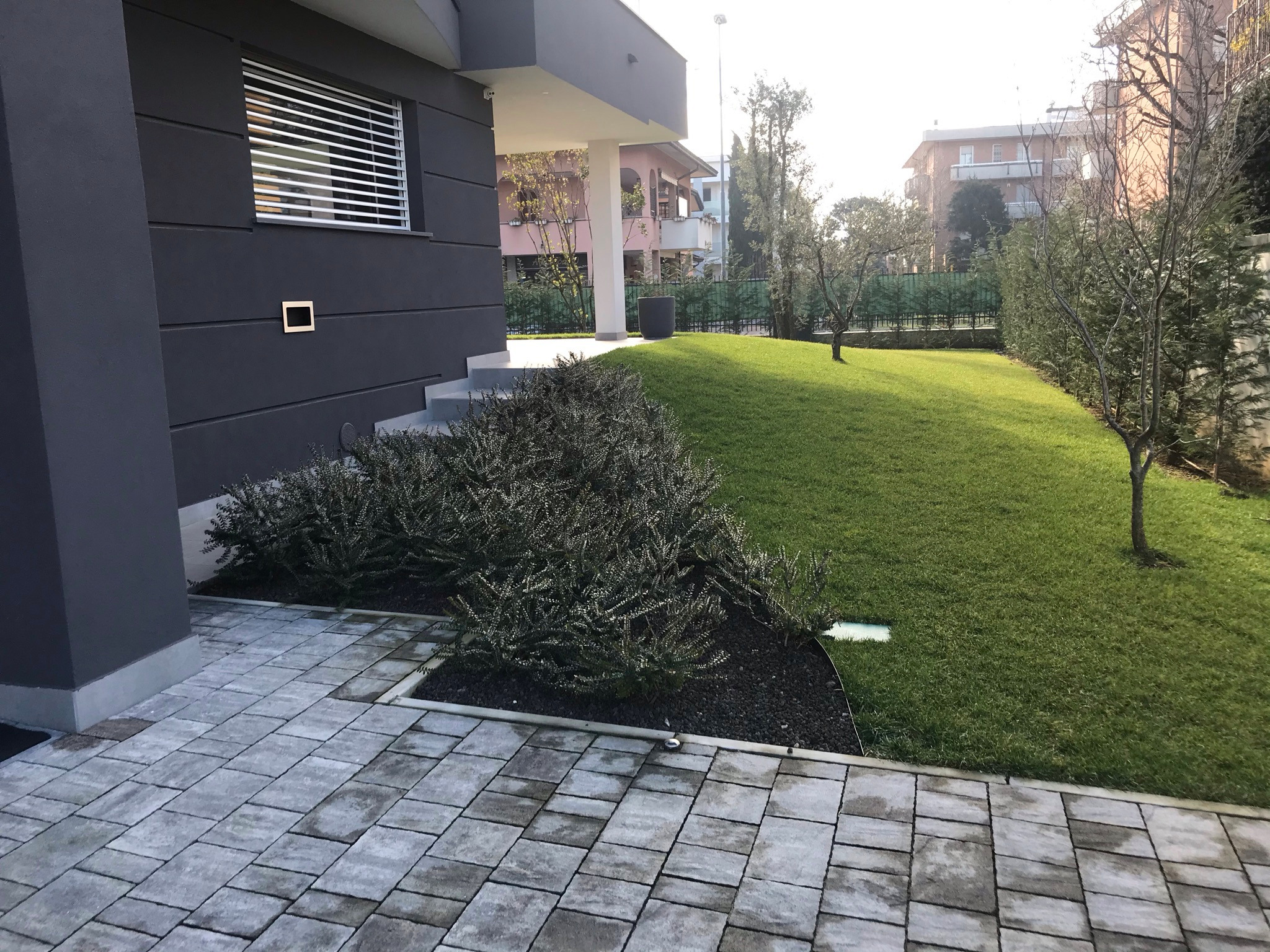 Giardino privato con percorso pavimentato e vegetazione
