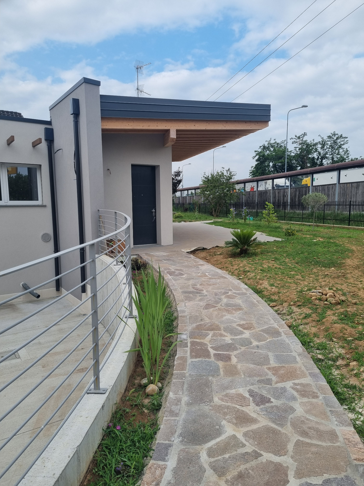 Percorso di ingresso della villa con copertura aggettante in legno